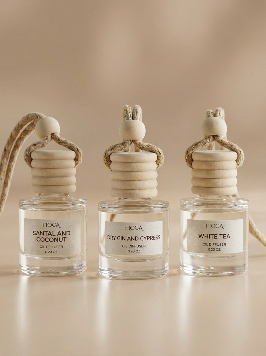 Three Fioca diffusers labeled 'Santal and Coconut', 'Dry Gin and Cypress', and 'White Tea' on a beige background.