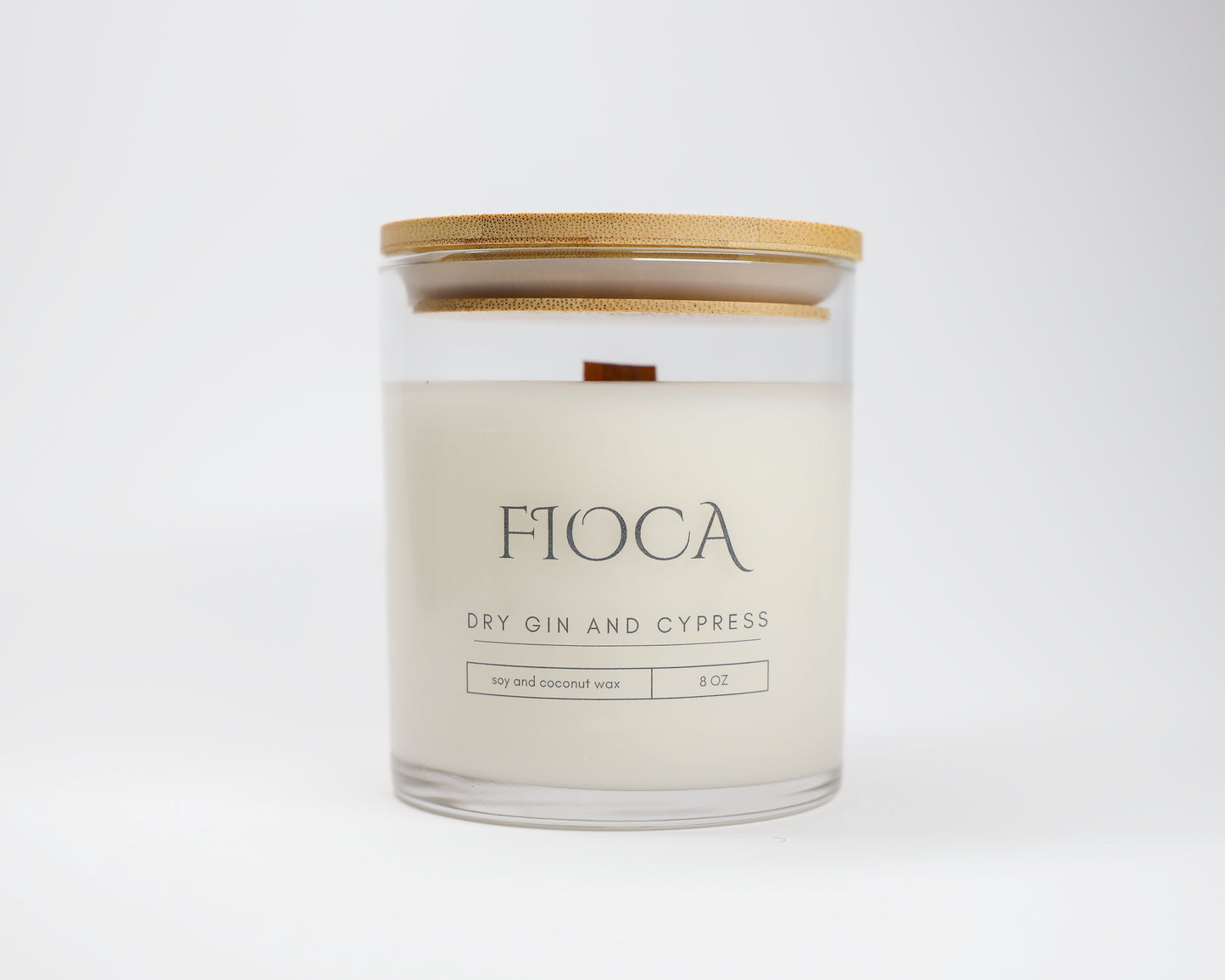 Studio image of Fioca Dry Gin and Cypress candle with bamboo lid against a white background, highlighting its clean, minimalist packaging