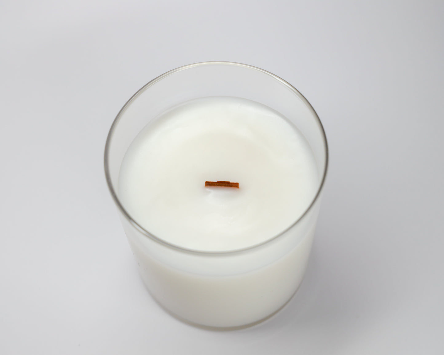 Top view of a Fioca candle showcasing its smooth soy and coconut wax blend with a natural wooden wick, emphasizing simplicity and purity